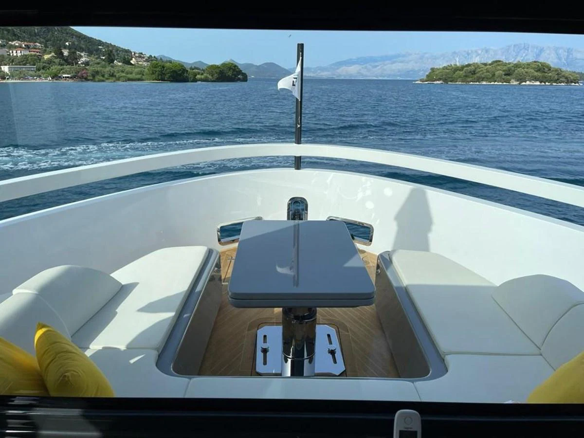 The foredeck features a sleek seating area with a central table, offering stunning views of the surrounding waters. aboard D&D Yacht for Sale