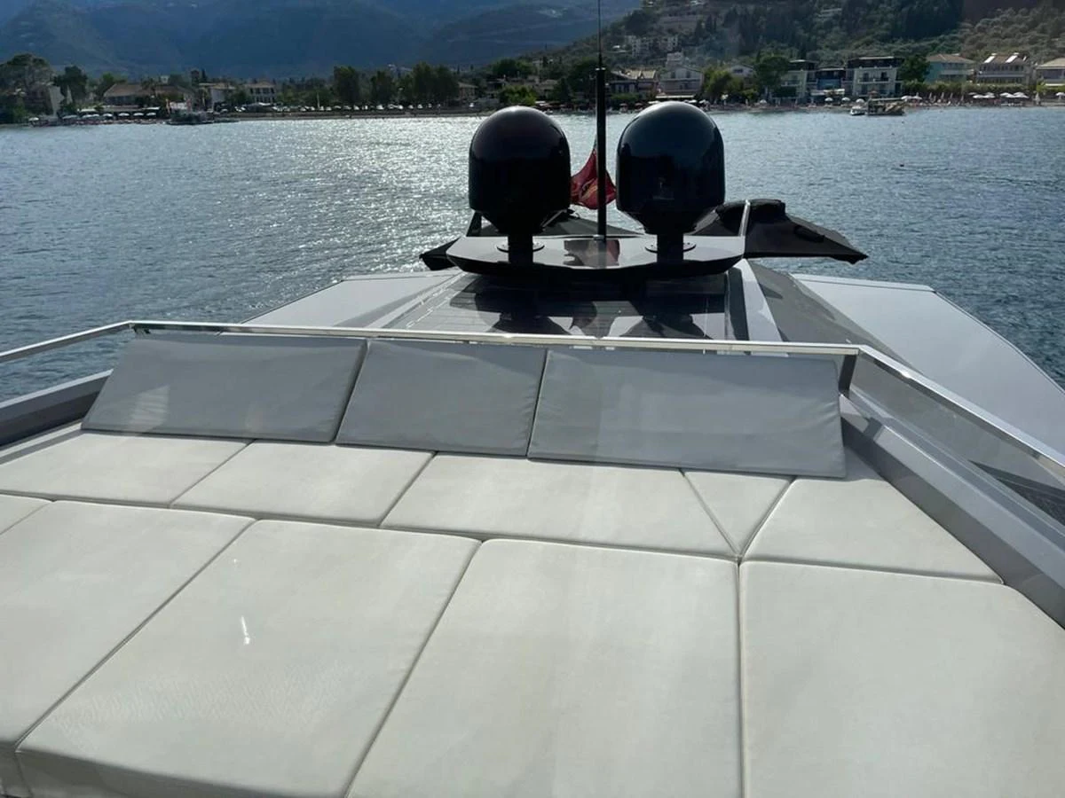 The yacht's foredeck features a spacious sunbathing area with comfortable cushions and a scenic view of the water and shoreline. aboard D&D Yacht for Sale