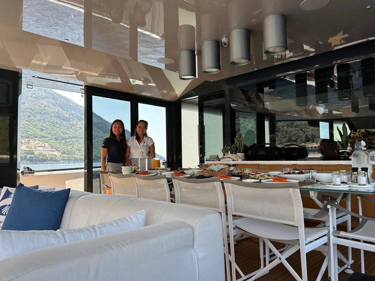 A comfortable dining area with a view of the surrounding landscape, featuring a set table and cozy seating. aboard D&D Yacht for Sale