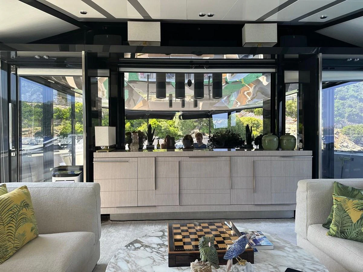 The yacht's interior features a luxurious and modern living area with large windows offering scenic views. aboard D&D Yacht for Sale