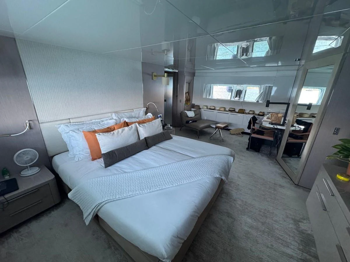 The stateroom features a plush bed with elegant linens and ample natural light from the windows. aboard D&D Yacht for Sale