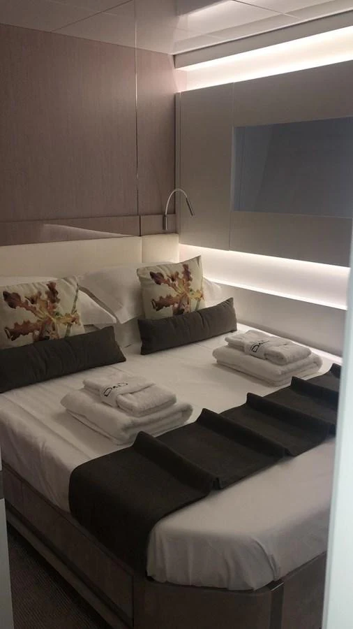 A cozy guest stateroom featuring a neatly made bed with decorative pillows and towels. aboard D&D Yacht for Sale
