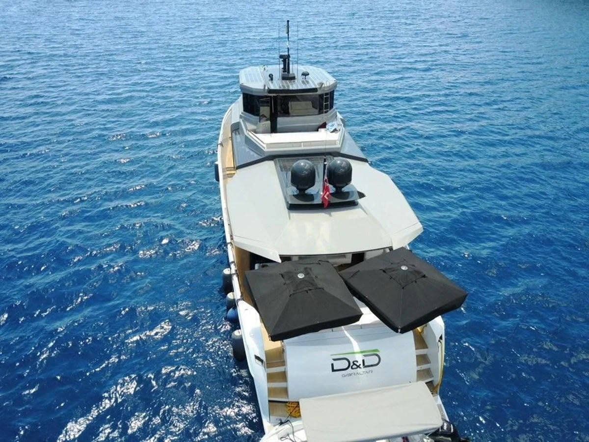 Aerial view of a yacht on the water with a spacious deck and sun umbrellas. aboard D&D Yacht for Sale