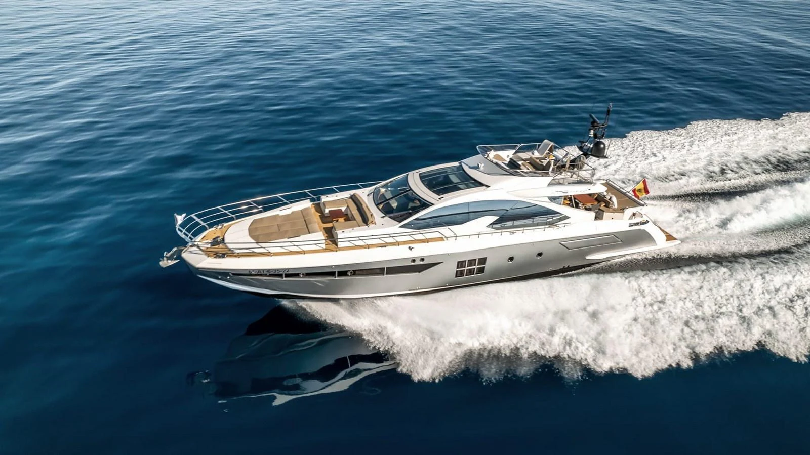 A sleek and modern yacht glides swiftly over calm blue waters, showcasing its luxurious design and powerful performance. aboard GRAN ABE II Yacht for Sale