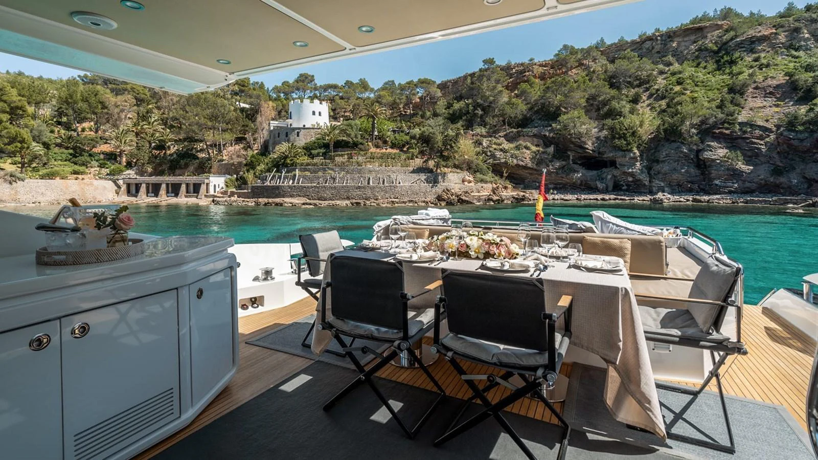 The aft deck features an elegant dining area with a stunning view of the surrounding landscape. aboard GRAN ABE II Yacht for Sale