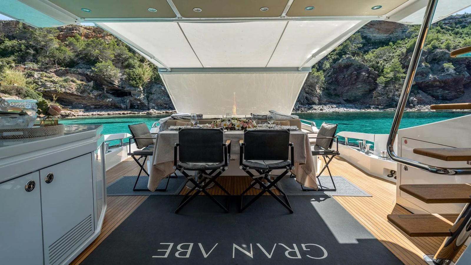 The aft deck features an elegant dining area with a stunning view of the surrounding waters. aboard GRAN ABE II Yacht for Sale