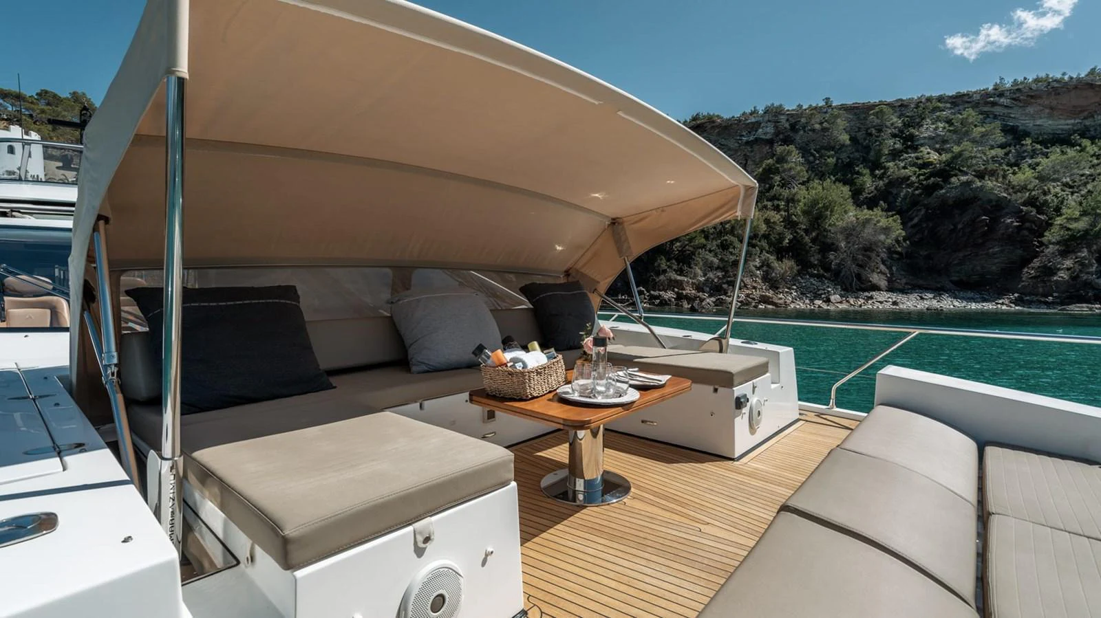 The aft deck features a comfortable lounging area with a sunshade and a table set for refreshments. aboard GRAN ABE II Yacht for Sale