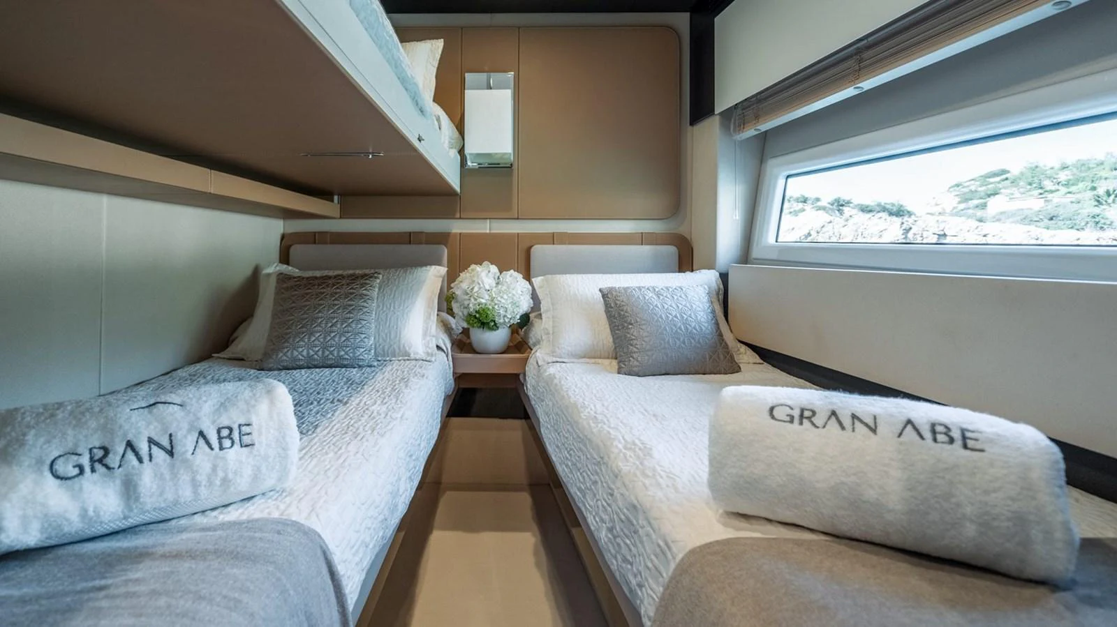 The guest stateroom features twin beds with elegant bedding and a scenic window view. aboard GRAN ABE II Yacht for Sale