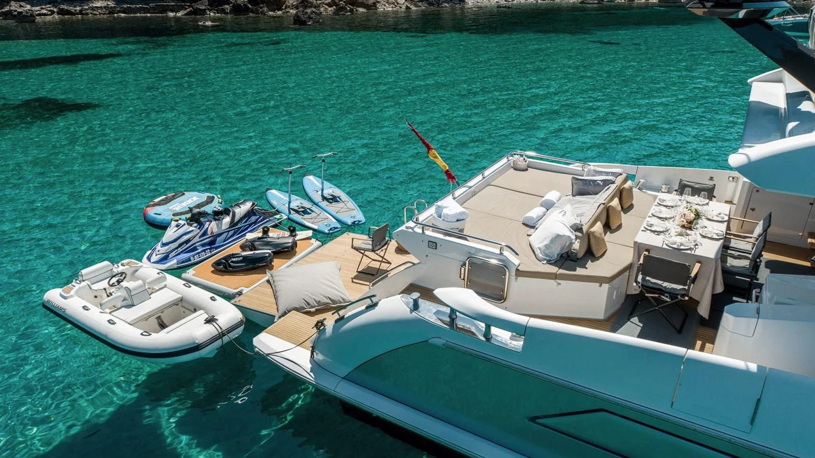 The yacht's aft deck offers a luxurious space for relaxation and dining, complemented by an array of water toys and a tender. aboard GRAN ABE II Yacht for Sale