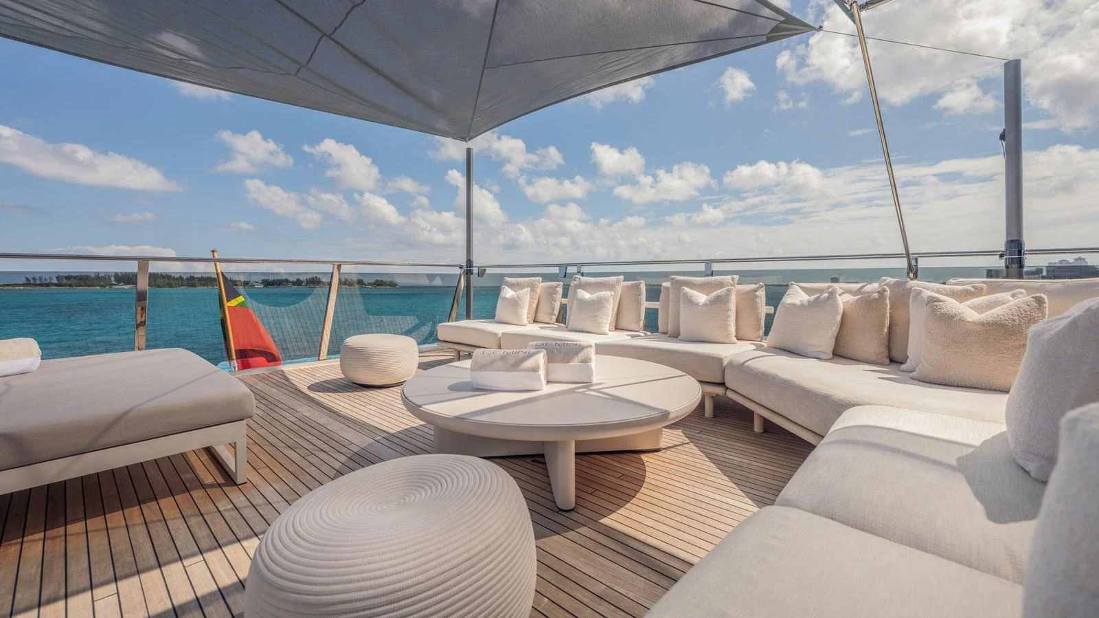 a lounge area with a large white lounge chair and a large white umbrella aboard GEMINI Yacht for Sale