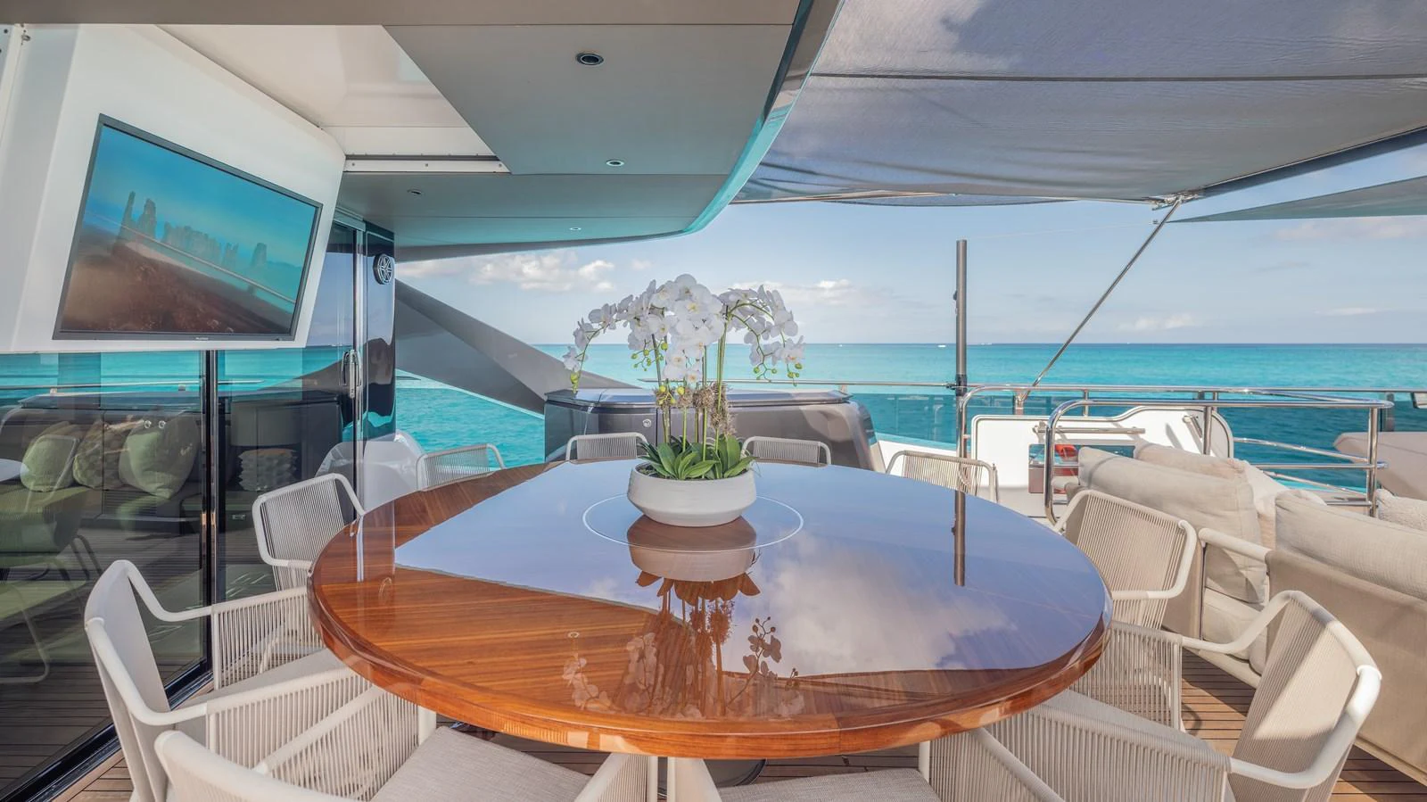 a table with chairs and a television on the wall aboard GEMINI Yacht for Sale