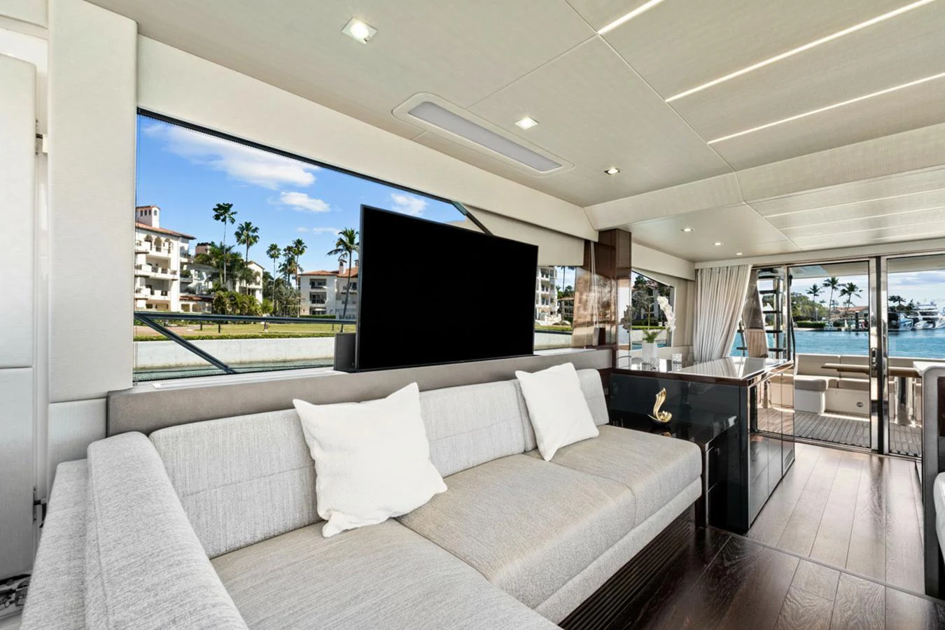 The yacht's salon features a spacious seating area with large windows offering scenic views. aboard SMITTEN Yacht for Sale