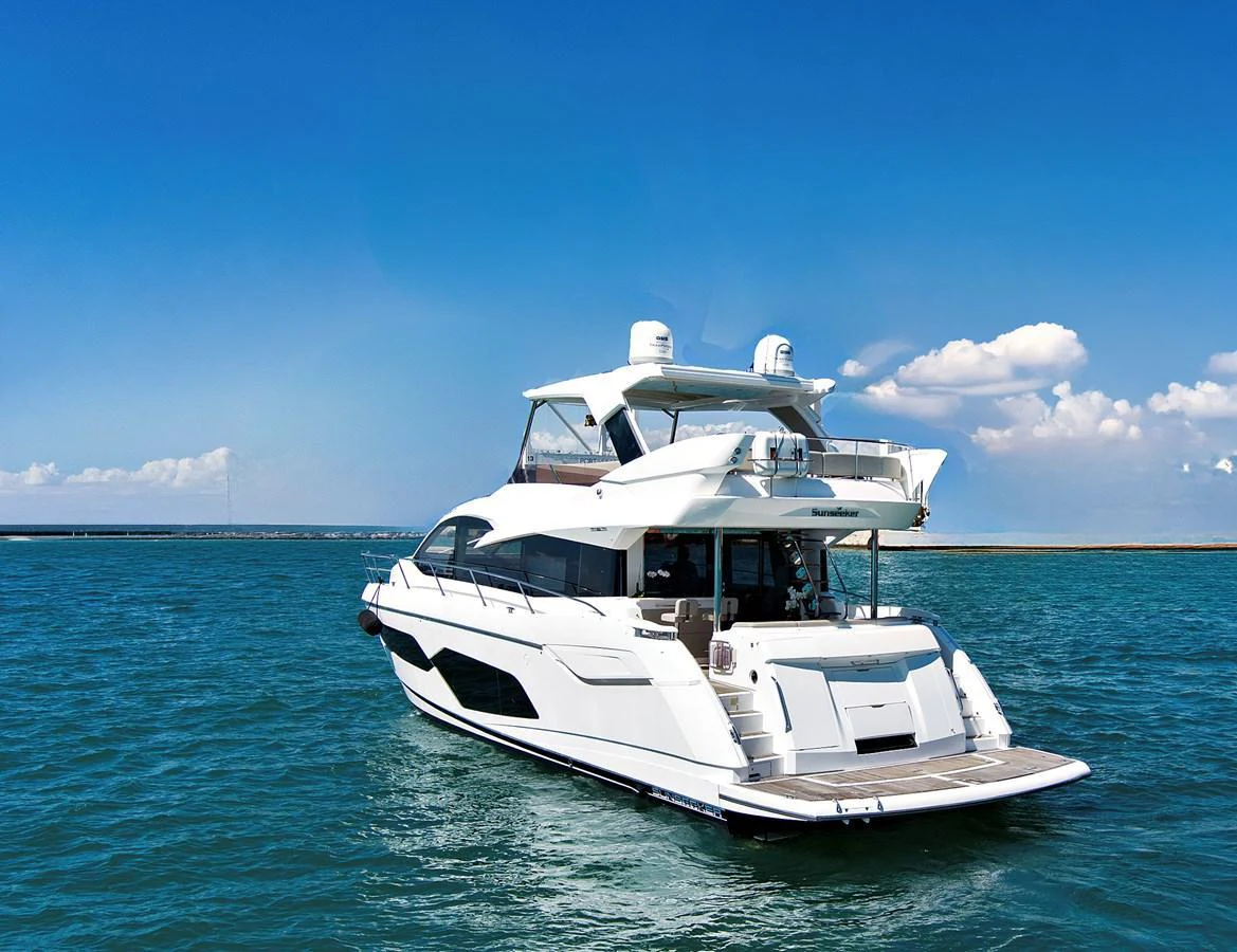 A sleek and modern yacht cruises on clear blue waters under a bright sky. aboard SMITTEN Yacht for Sale