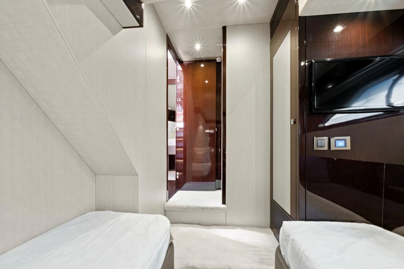 The guest cabin features twin beds and a sleek, modern design with ample lighting. aboard SMITTEN Yacht for Sale