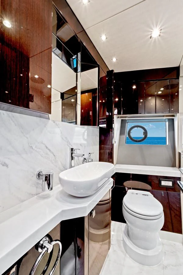 The yacht's bathroom features elegant finishes with a modern sink and a view of the sea. aboard SMITTEN Yacht for Sale