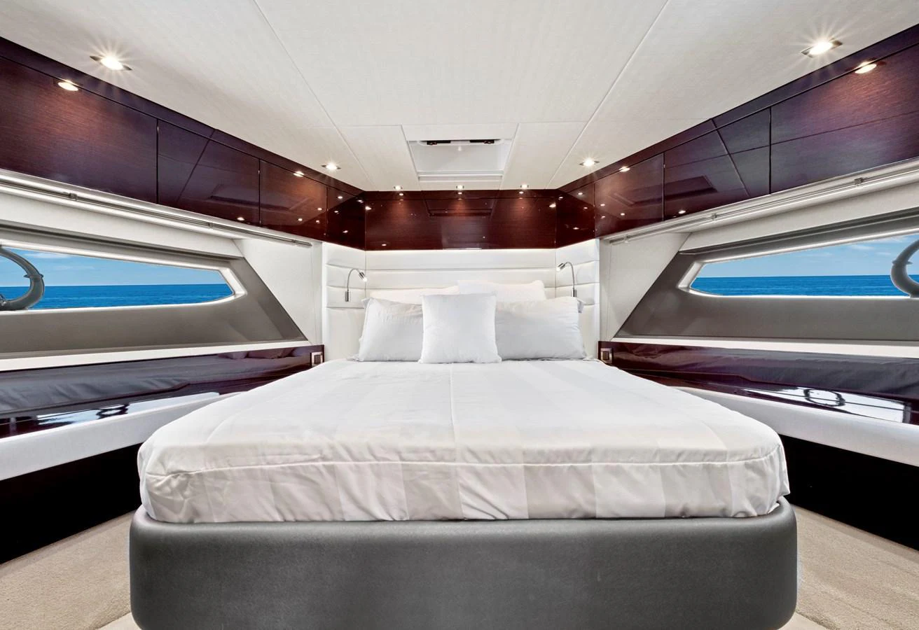 The master stateroom features a luxurious bed with panoramic ocean views through large windows. aboard SMITTEN Yacht for Sale