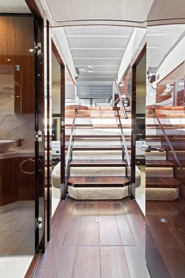 A beautifully designed interior staircase with wooden steps and modern finishes. aboard SMITTEN Yacht for Sale