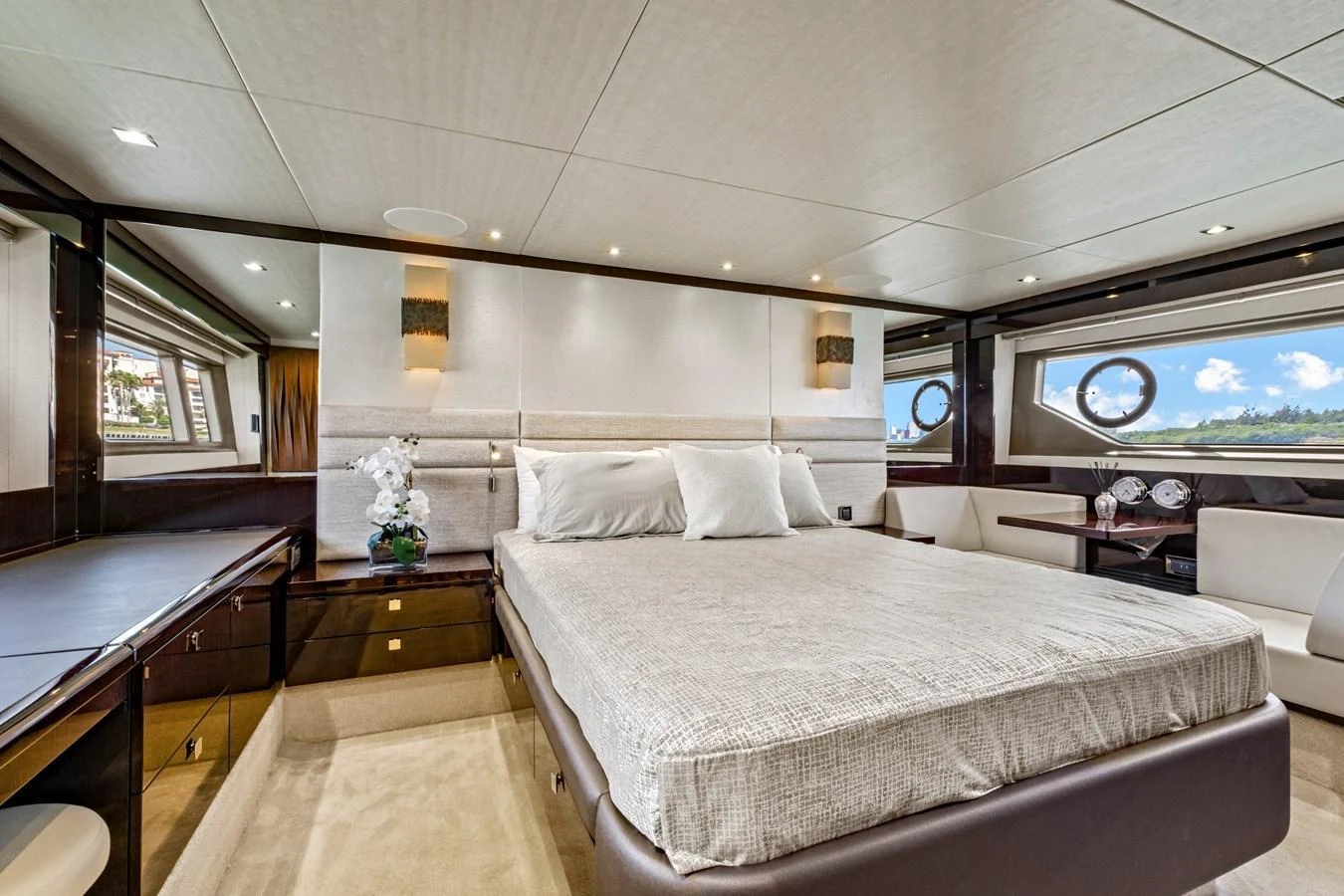 The master stateroom features a spacious bed with elegant decor and ample natural light from large windows. aboard SMITTEN Yacht for Sale