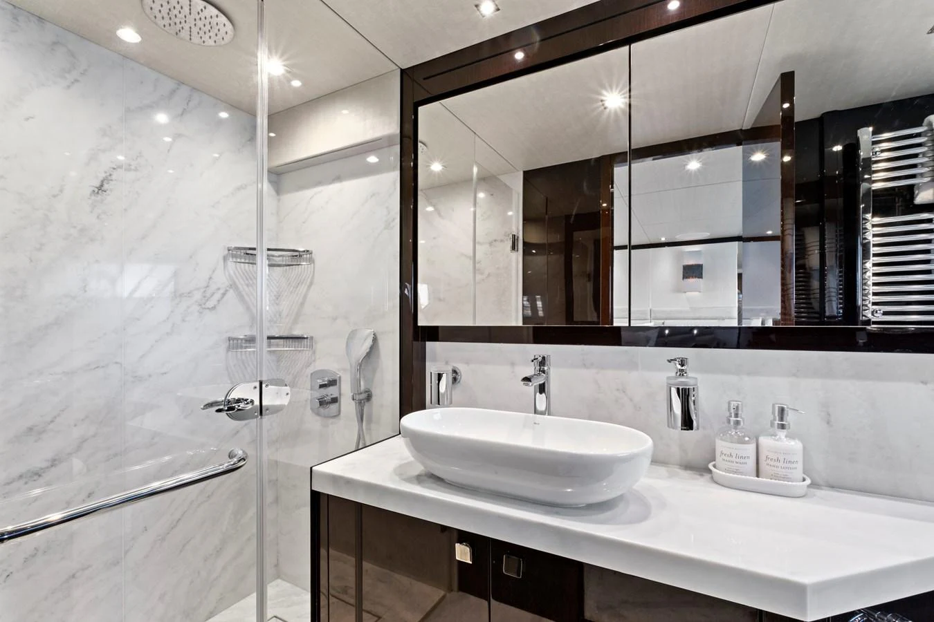 The yacht's bathroom features a sleek, modern design with a spacious shower and elegant fixtures. aboard SMITTEN Yacht for Sale
