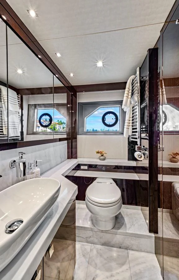 A luxurious yacht bathroom with modern fixtures and a scenic window view. aboard SMITTEN Yacht for Sale