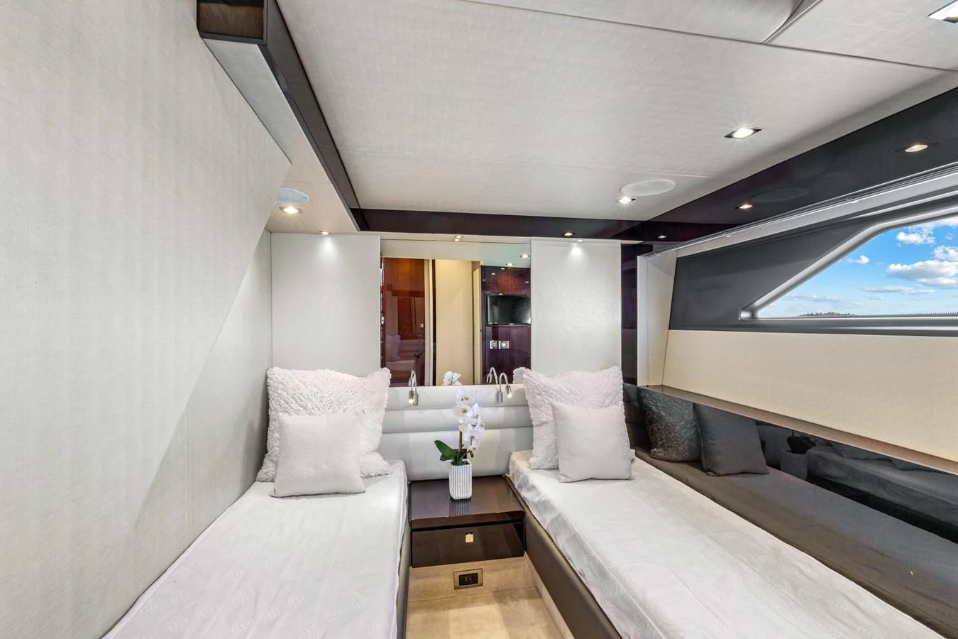 The guest stateroom features twin beds and modern decor, offering a comfortable and stylish retreat. aboard SMITTEN Yacht for Sale