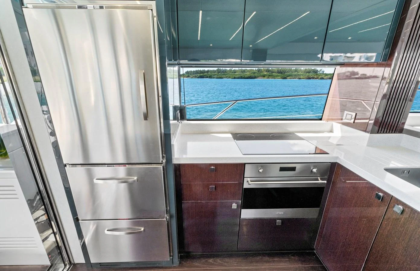 The modern galley features sleek stainless steel appliances and a stunning view of the water. aboard SMITTEN Yacht for Sale
