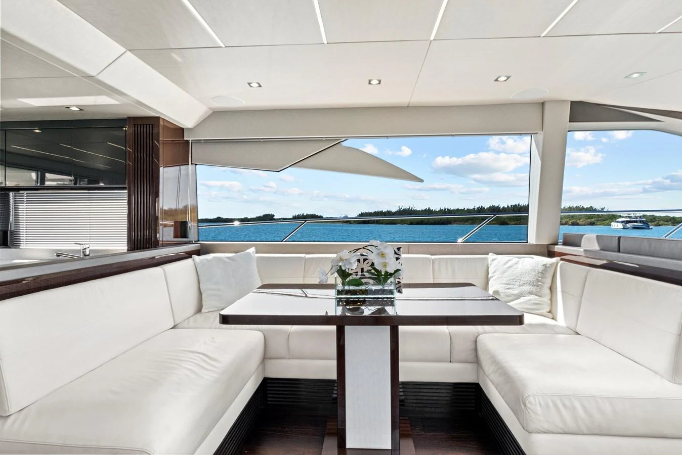 The salon features a spacious seating area with a large window offering stunning ocean views. aboard SMITTEN Yacht for Sale