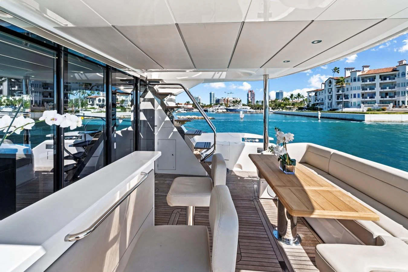 The aft deck features a comfortable seating area with a wooden table, perfect for enjoying the view. aboard SMITTEN Yacht for Sale