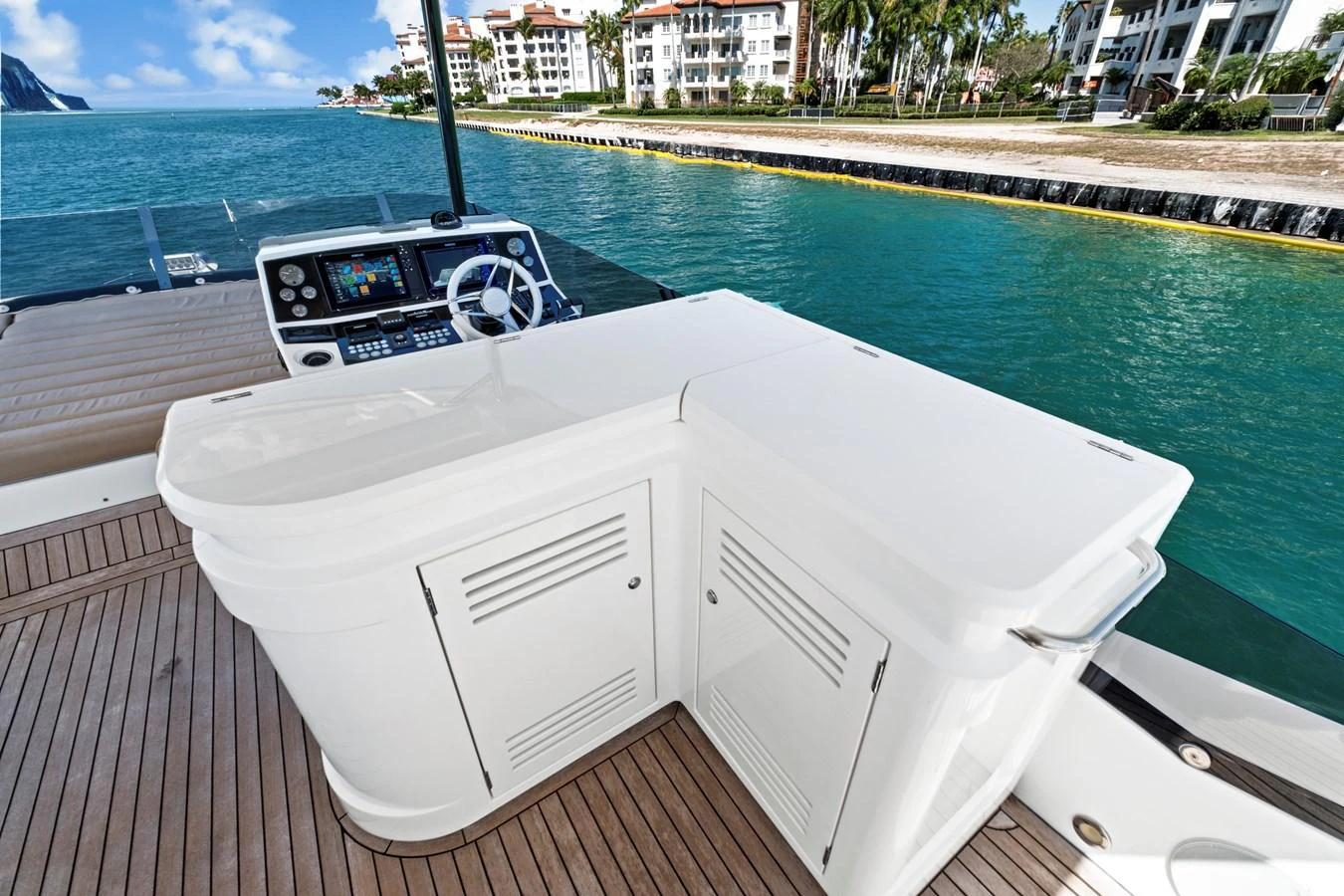 The flybridge features a sleek outdoor kitchen area with stunning waterfront views. aboard SMITTEN Yacht for Sale