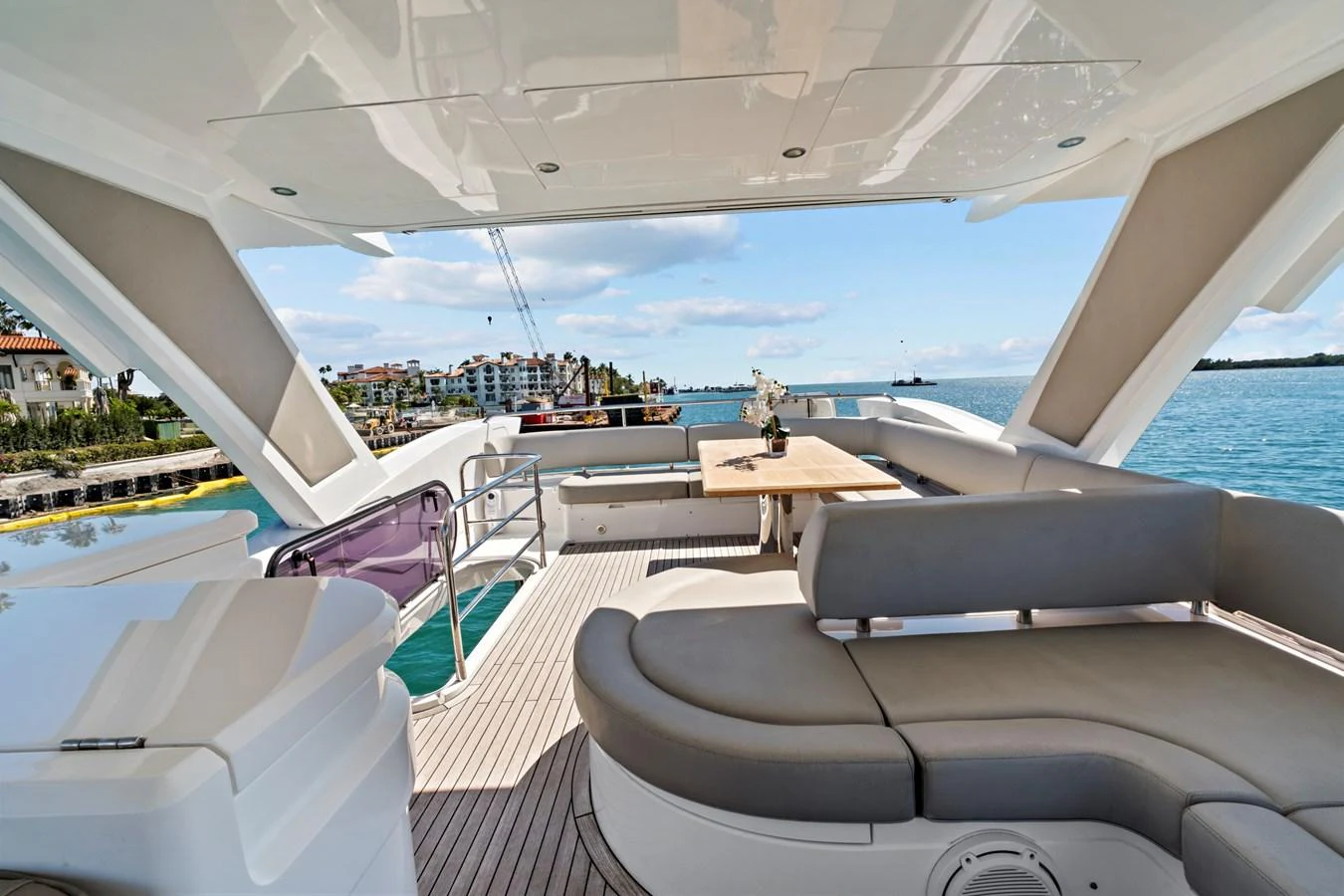 The flybridge offers a spacious seating area with a dining table and panoramic views. aboard SMITTEN Yacht for Sale