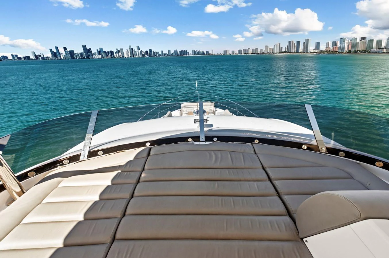 The yacht's bow offers a luxurious sunbathing area with stunning city skyline views. aboard SMITTEN Yacht for Sale
