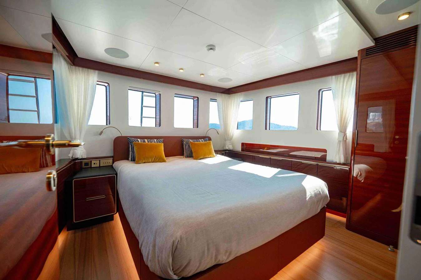 The master stateroom features a spacious bed with ample natural light from multiple windows. aboard VERO Yacht for Sale