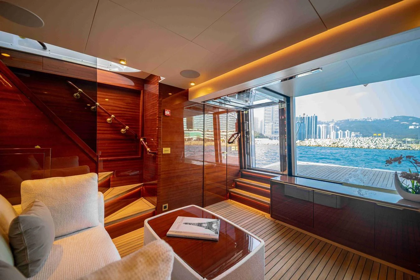 A luxurious interior space with a stunning view of the city skyline through large windows. aboard VERO Yacht for Sale