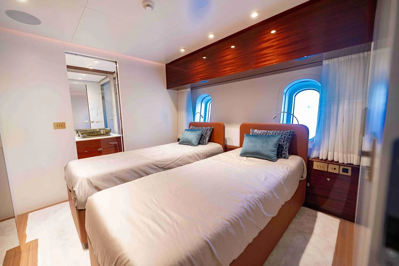 The guest stateroom features twin beds with elegant bedding and a modern, cozy ambiance. aboard VERO Yacht for Sale