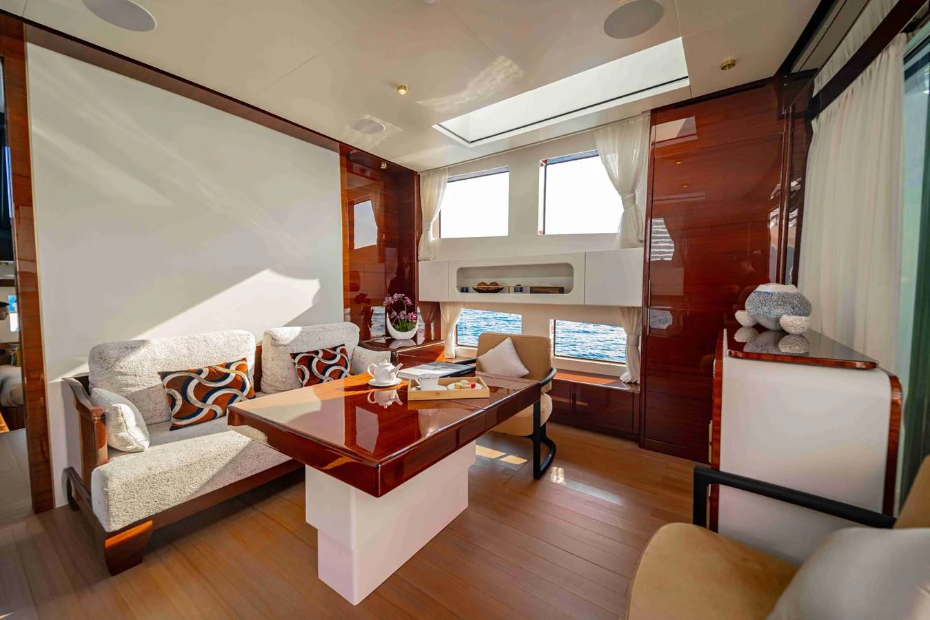 The yacht's salon features elegant seating, a stylish table, and large windows offering stunning sea views. aboard VERO Yacht for Sale