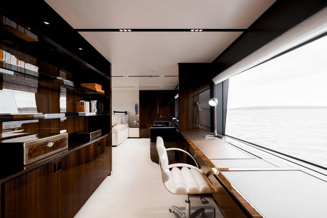 This yacht features a sophisticated office space with a large window offering a stunning view of the sea. aboard LADY FIRST Yacht for Sale