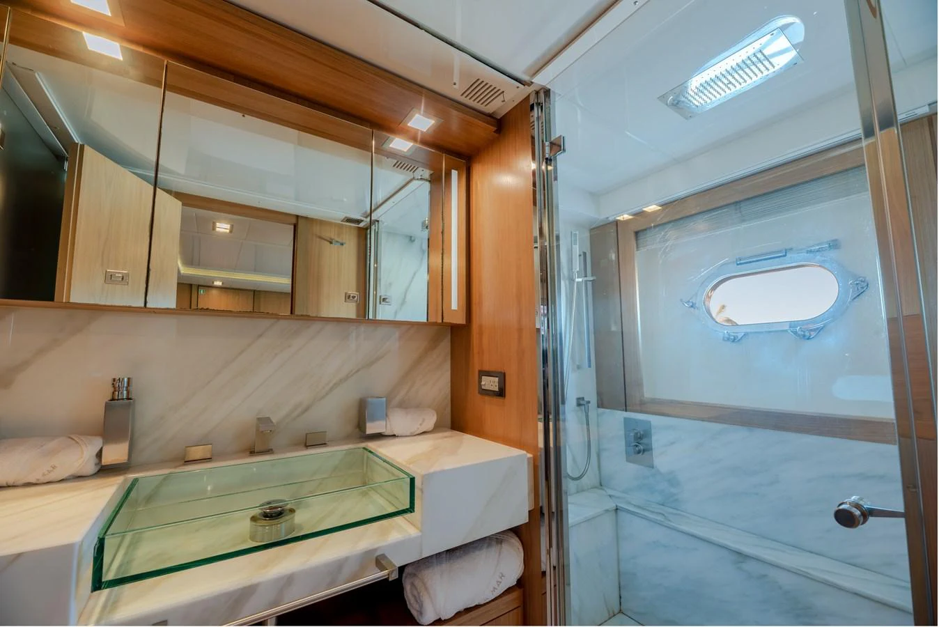 The yacht's bathroom features a modern design with a glass sink and a spacious shower area. aboard AMORE MIO Yacht for Sale