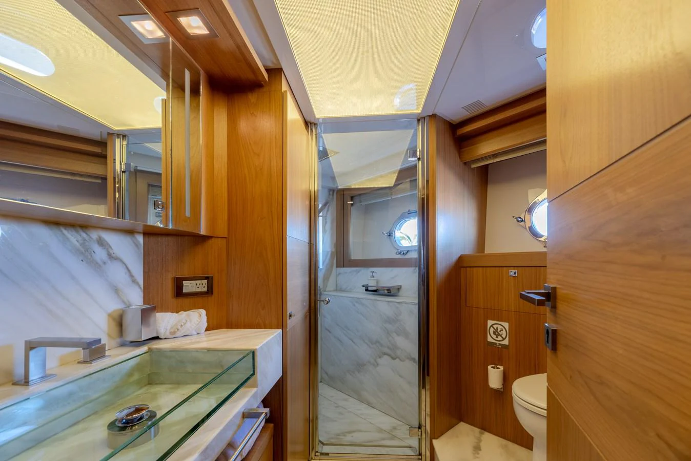 The yacht's bathroom features elegant wood paneling and modern fixtures, creating a luxurious and comfortable space. aboard AMORE MIO Yacht for Sale