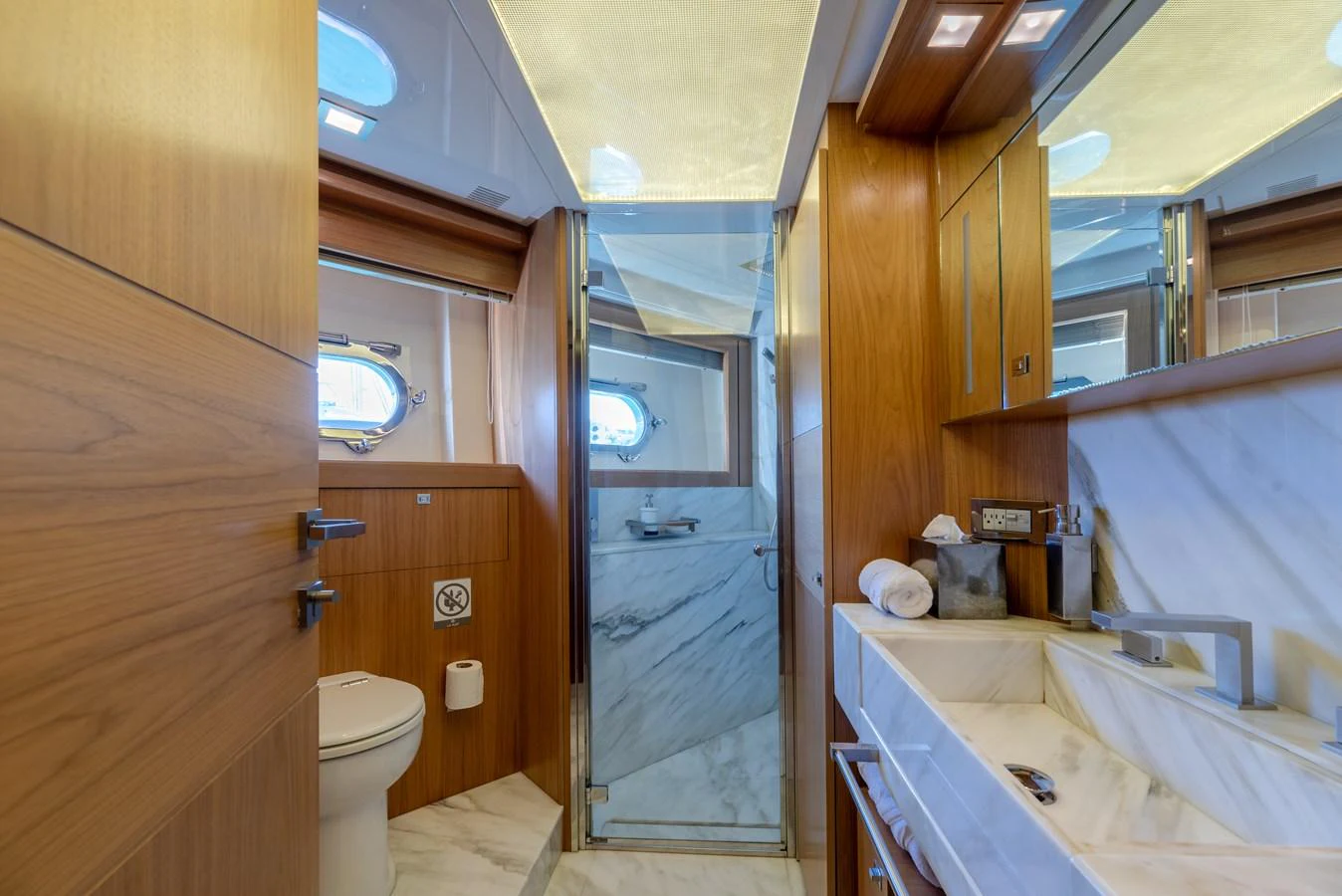 The yacht's bathroom features elegant wood paneling and a modern marble sink. aboard AMORE MIO Yacht for Sale