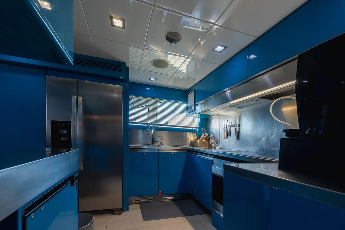 The yacht's galley features sleek blue cabinetry and modern stainless steel appliances. aboard AMORE MIO Yacht for Sale