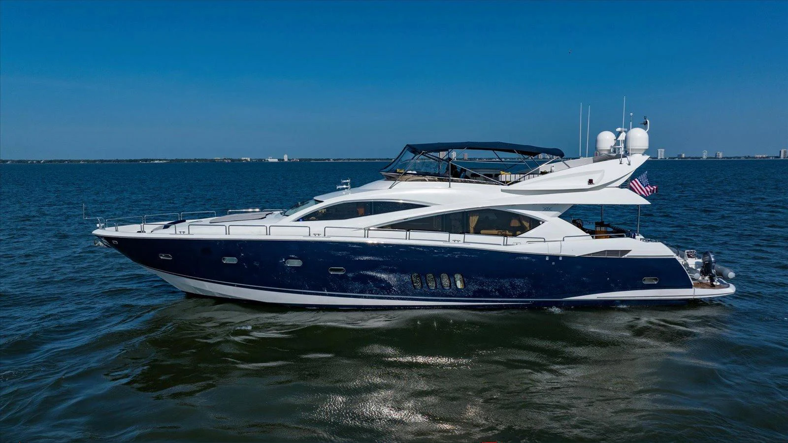 A sleek and modern yacht cruising on calm waters under a clear blue sky. aboard VANGUARD Yacht for Sale