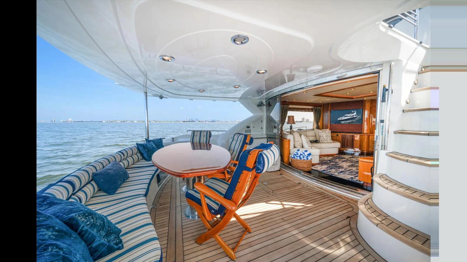 The aft deck offers a comfortable outdoor seating area with a view of the sea and easy access to the interior lounge. aboard VANGUARD Yacht for Sale
