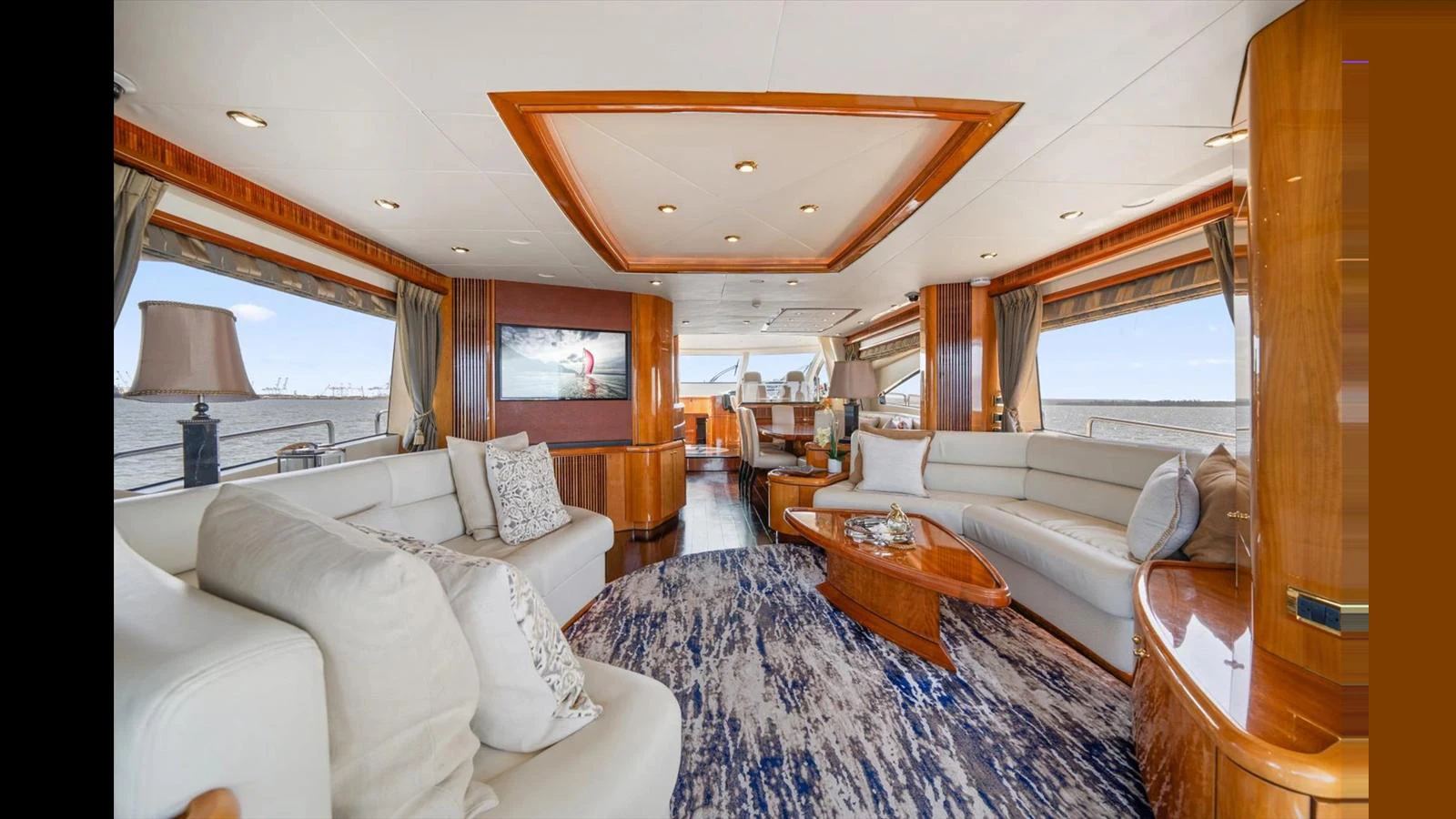The yacht's salon features luxurious seating, elegant wood finishes, and expansive windows offering stunning views. aboard VANGUARD Yacht for Sale