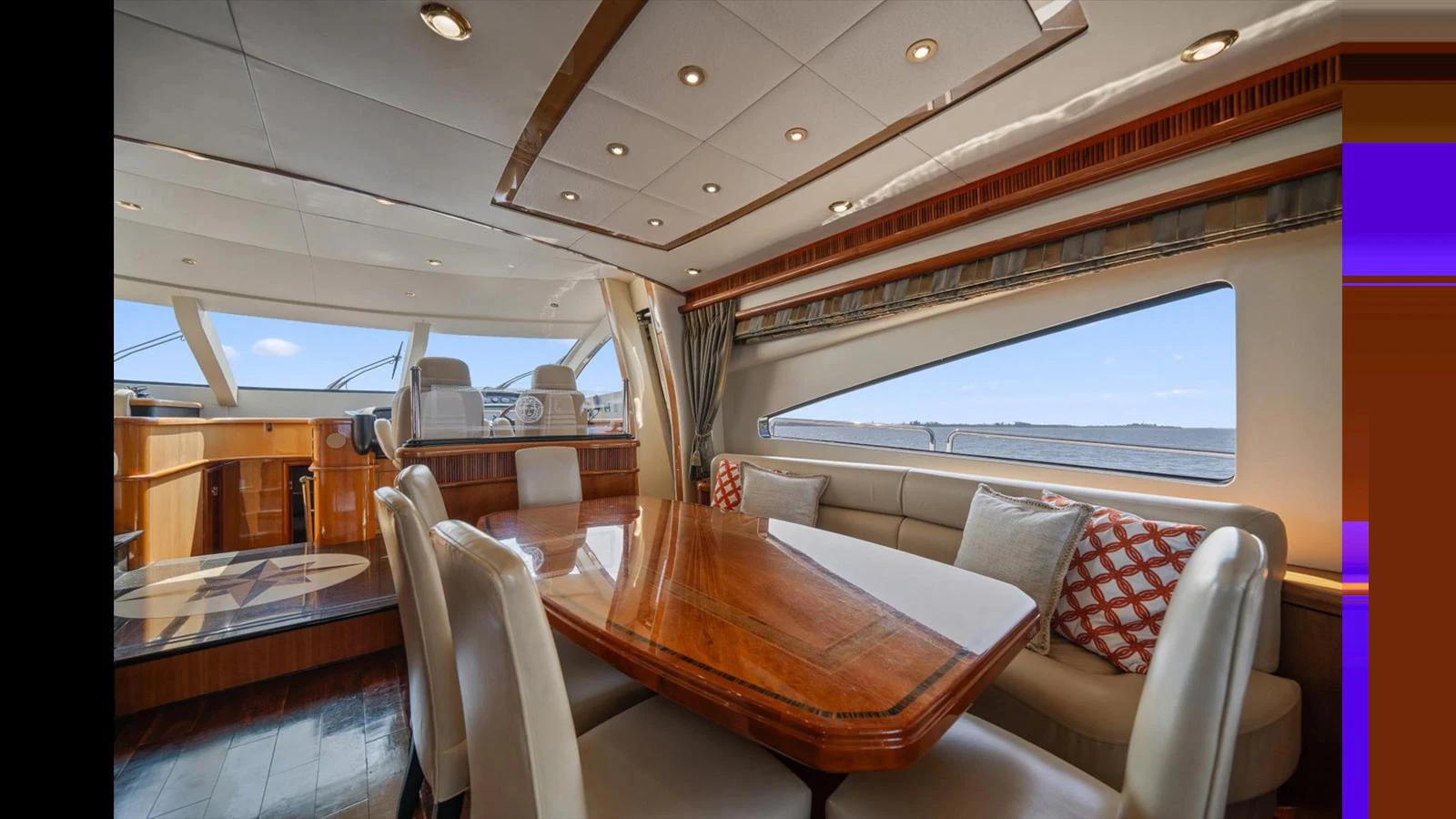 The yacht's dining area features a polished wooden table surrounded by comfortable seating, with large windows offering scenic views. aboard VANGUARD Yacht for Sale