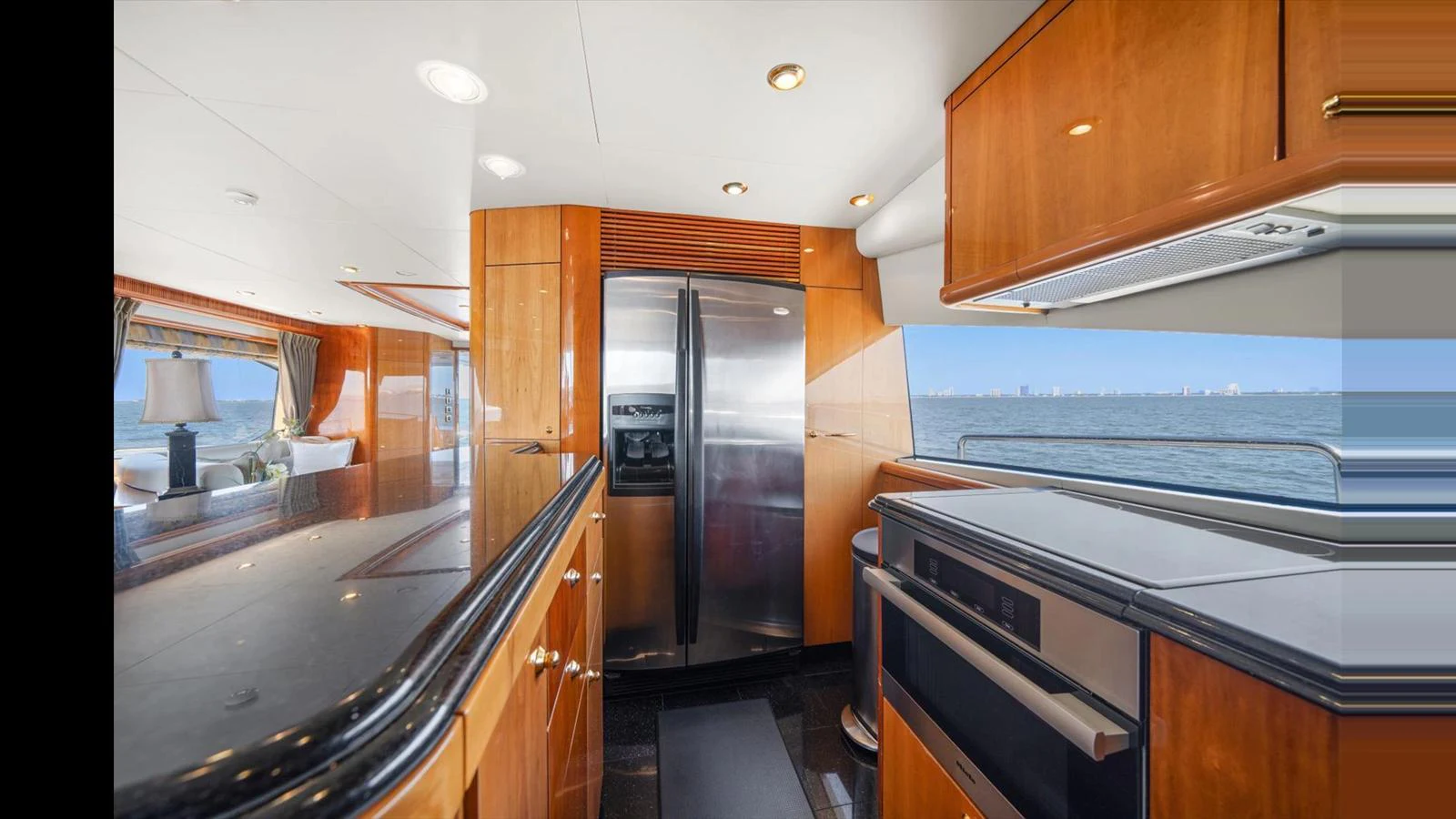 The yacht's galley features modern appliances and sleek wooden cabinetry with a view of the sea. aboard VANGUARD Yacht for Sale