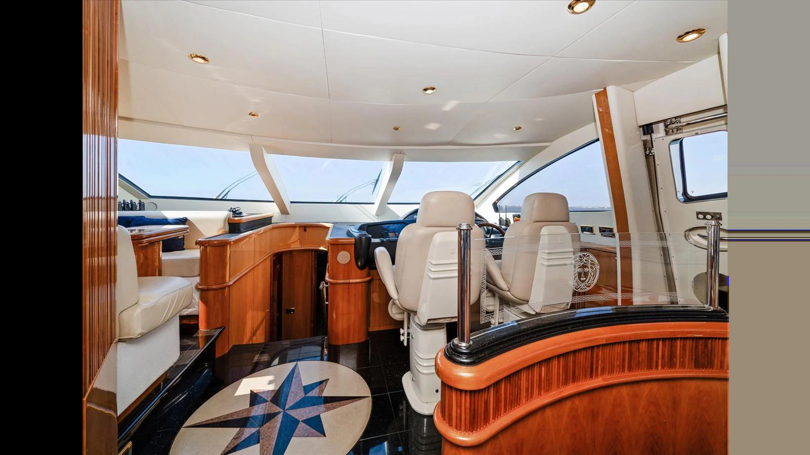 The helm area features luxurious seating and a sophisticated control panel with panoramic windows. aboard VANGUARD Yacht for Sale