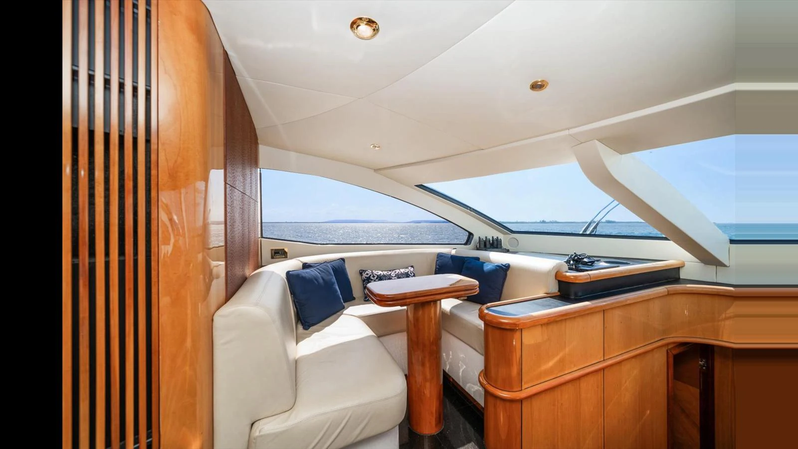 The yacht's salon features a comfortable seating area with a stunning view of the sea. aboard VANGUARD Yacht for Sale