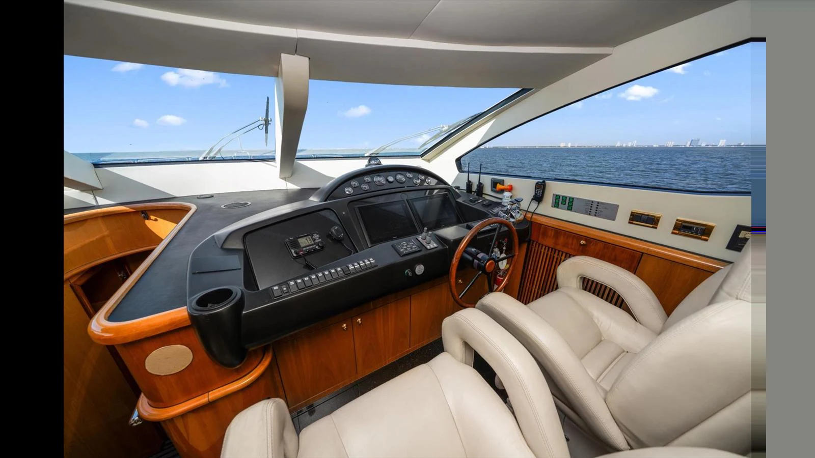 The helm features comfortable seating and advanced navigation equipment with a stunning ocean view. aboard VANGUARD Yacht for Sale