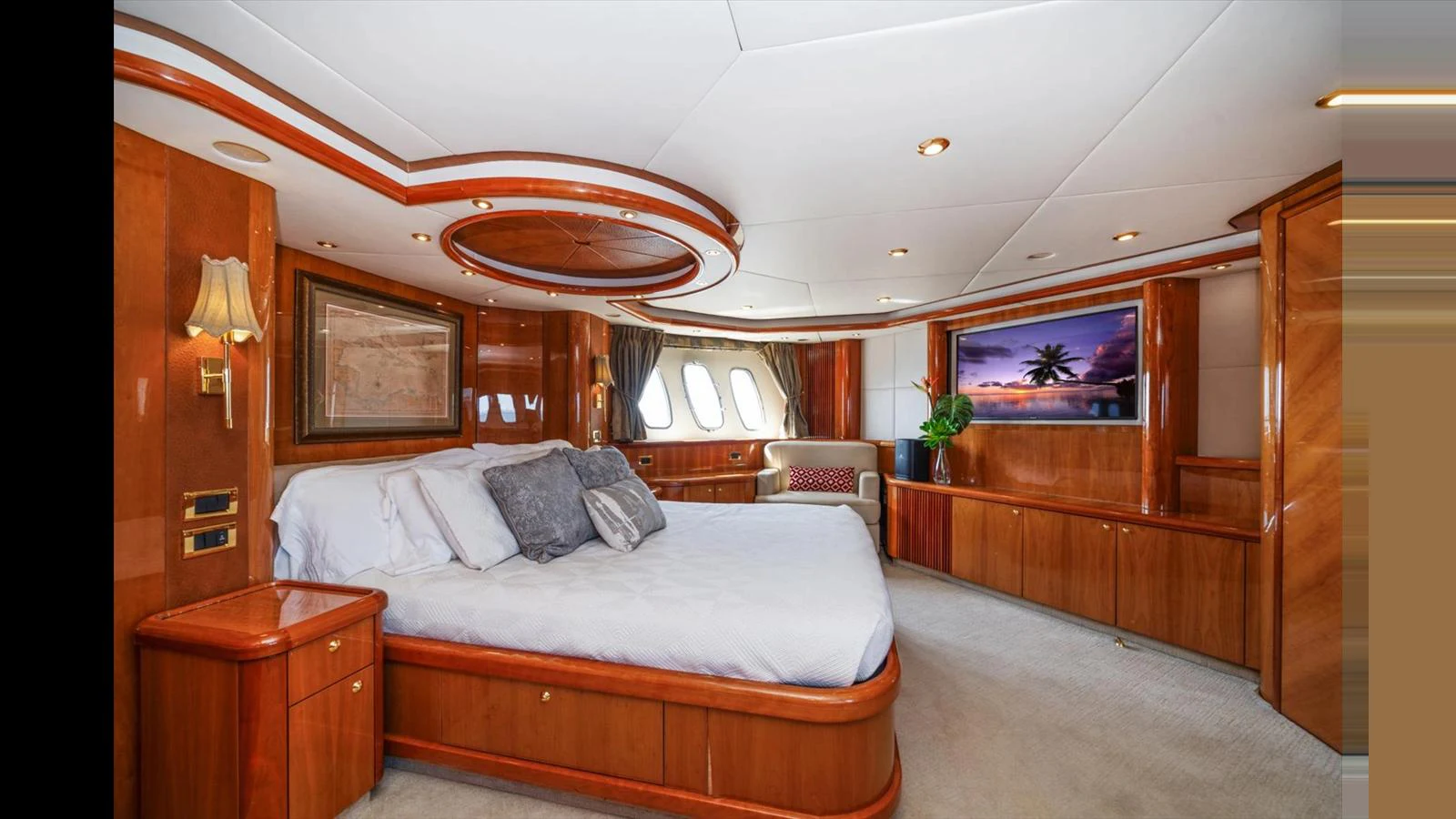 The master stateroom features elegant wood paneling and a large bed with luxurious bedding. aboard VANGUARD Yacht for Sale