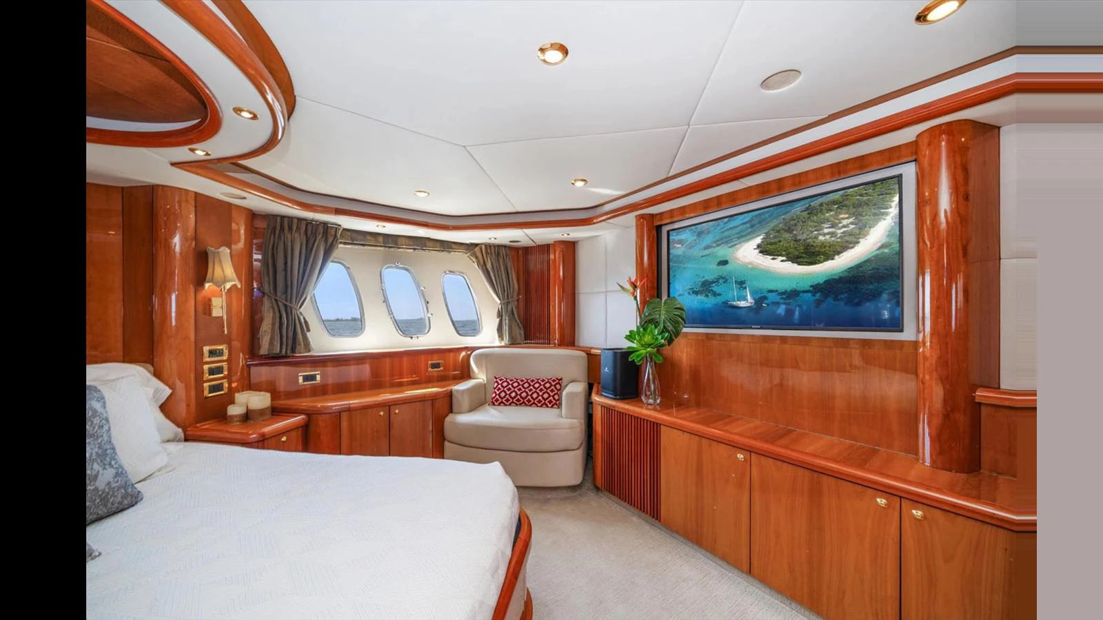 The master stateroom features elegant wood finishes and a large window with a scenic view. aboard VANGUARD Yacht for Sale